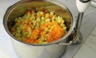 Voeg gebakken wortels en courgette toe aan de pan met de uien. Gewapend met een onderwaterapparaat, maal tot een gladde massa. Zet de pan op middelmatige temperatuur, dek af en laat een half uur koken.