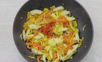 Doe vervolgens de knoflook, gehakt door een knoflookpers, en stukjes chilipeper in de koekenpan en bak 1 minuut op middelhoog vuur.