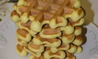 Acoperiți aparatul și coaceți până devine maro auriu. Procesul durează 5-7 minute. Gătim toate produsele de copt în acest fel până se termină aluatul. Puneți vafele pregătite într-o stivă. Poftă bună!