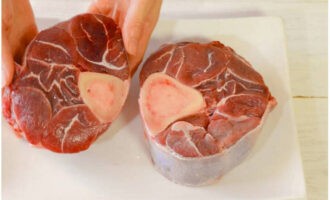 Osso buco tillagas mycket enkelt enligt det klassiska receptet. Skölj nötbensbiffarna väl under vatten.