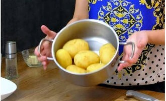 Les patates amb formatge al forn es preparen de manera ràpida i senzilla. Després de pelar les patates, coure els tubercles, després de bullir, durant 20 minuts en aigua amb sal. Després de bullir les patates, les deixem refredar.