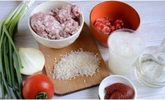 Ris med köttfärs är väldigt lätt att tillaga. Vi förbereder ingredienser till en enkel men aptitretande rätt. Efter att ha sköljt ett glas ris tills vattnet är klart, placera en kastrull på spisen med 300 milliliter vätska (i det här fallet använder vi buljong) och flingor.