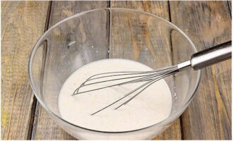 Khachapuri volgens het klassieke recept wordt heel eenvoudig bereid. Meng de melk in een diepe kom met water, verwarm en roer de gist en suiker erdoor. Laat gedurende 10 minuten staan.