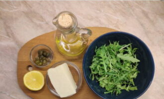 El formatge halloumi fregit en una paella és molt fàcil de preparar. Preparem el joc de menjar: rentem bé les fulles de rúcula i les posem sobre un colador per escórrer l'excés d'aigua.