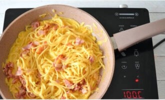 Efter att du silat spaghettin, lägg den i en het stekpanna. Häll i såsen och blanda väl. Tillsätt det stekta baconet och rör om igen. Rör om, värm i en minut.