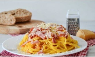 Fördela carbonarapastan mellan tallrikar och strö över parmesanost. Smaklig måltid!