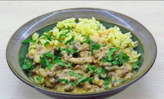 Klassisk biff stroganoff i en stekpanna är klar. Servera med tillbehör. Du kan dekorera med färska örter.