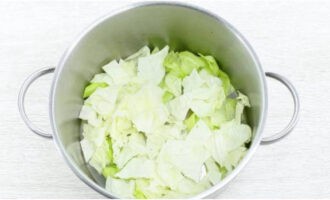 Để nấu món bắp cải cuộn, hãy lấy một cái chảo lớn và đặt một lớp lá bắp cải còn lại thái nhỏ xuống đáy.