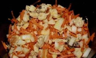Skala och skölj grönsakerna. Skär morötterna i tunna strimlor och löken i tunna kvartsringar. Efter 15 minuter, tillsätt hackade grönsaker i den stekta kycklingfilén och fortsätt steka under samma tid.