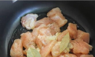 Gupitin ang fillet ng manok sa mga di-makatwirang hiwa, ilagay sa isang mangkok na may pinainit na langis ng mirasol (magprito ng 10 minuto), timplahan ng asin, isang pakurot ng paminta at dahon ng bay - magprito ng 5-6 minuto.