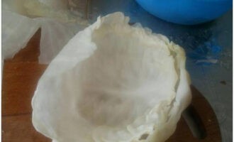 După timpul specificat, îl scoatem și separăm cele 2-3 frunze de sus, care au devenit moi, tăiem părțile dense ale frunzelor. Pune din nou capul de varză în apă clocotită și repetă aceiași pași până când varza dispare. Tăiați cu grijă părțile dense.