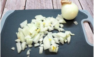 Balatan ang sibuyas at i-chop ito ng makinis gamit ang kutsilyo.
