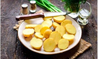 Was de aardappelknollen grondig met een spons, dep ze droog met servetten en snijd ze doormidden.