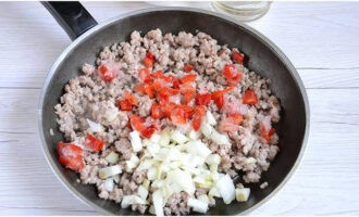 Skala löken och hacka den. Skär de tvättade tomaterna och paprikan i tärningar. Vi lastar av de hackade grönsakerna på den stekta köttfärsen. Efter omrörning, koka i 7 minuter.
