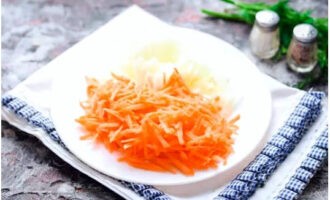 Skala och hacka löken och morötterna: hacka löken slumpmässigt, och riv morötterna på ett grovt rivjärn. Stek de förberedda ingredienserna i vegetabilisk olja tills de är mjuka och gyllene.
