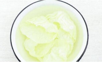 Làm nguội lá bắp cải luộc trong tô nước lạnh.