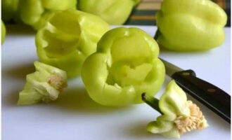 Balatan ang mga bell pepper na may parehong laki mula sa mga tangkay na may mga partisyon at buto, at banlawan.
