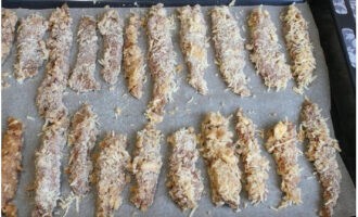 Klä en bakplåt med silikoniserat bakplåtspapper. Doppa den marinerade kycklingfilén i uppvispade ägg och rulla i ströbröd och ost. Lägg de panerade bitarna på en plåt.