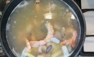Efter 15 minuter, tillsätt tom yum-pasta, svamp, räkor och fisksås.