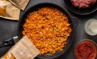 När löken blivit genomskinlig, tillsätt söt och het paprika, vitlök, spiskummin, paprika och mald chilipeppar – blanda väl och koka i 5 minuter.
