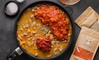 I det ögonblick när köttkomponenten nästan är klar, kompletterar vi kompositionen med buljong, mosade tomater och tomatpuré, socker, mejram, salt och mald peppar. Rör om, låt koka upp, sänk värmen och låt sjuda under lock i 20 minuter.