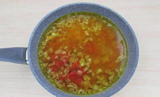 Häll kokande vatten över löken och tillsätt tomatpuré.