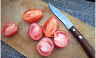 Dela tomaterna på längden.