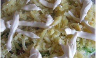 A harmadik réteg friss uborka lesz, majd adjuk hozzá a reszelt burgonyát, sózzuk és kenjük be majonézzel.