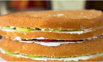 A continuació, repartiu la nata per sobre del pastís, disposeu les baies i les fruites i repetiu el pas anterior. Així que munteu tot el pastís a partir de quatre capes.