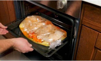 Col·loqueu la màniga amb arròs i pollastre en una safata per al forn. Col·loqueu la peça de treball en un forn preescalfat a 180 graus. Coure el plat durant 1,5 hores.