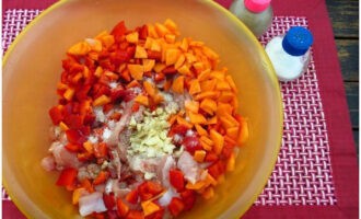 I en skål, kombinera kyckling, paprika, morötter och vitlök. Till denna blandning tillsätt salt, curry, torkad timjan och mald svartpeppar.