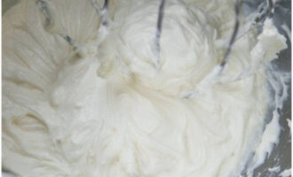 A continuació, en un bol, batem el formatge crema i el sucre en pols fins que quedi esponjós. A continuació, aboqueu la nata i continueu batent fins que es formin pics rígids.