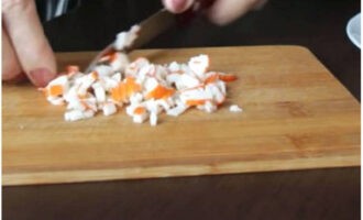 Làm thế nào để chuẩn bị món salad đơn giản và ngon miệng cho bàn ăn ngày lễ? Lấy que cua ra khỏi bao bì và cắt thành khối nhỏ.