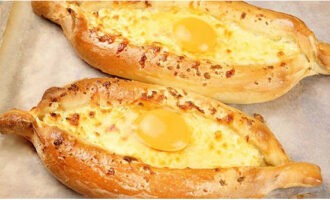 Een paar minuten voordat je klaar bent, scheur je de kaas lichtjes in het midden en breek je het ei. Haal de schaal na een paar minuten uit de oven en kruid de zijkanten en vul ze met kleine plakjes boter.