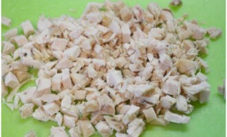 Hoe maak je snel een eenvoudige en smakelijke salade? Snij de kipfilet in blokjes. Kook het vlees in gezouten water met kruiden en, om te voorkomen dat het vlees uitdroogt, koelt u het af in de bouillon.