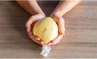 Apoi, folosiți mâinile pentru a frământa într-un bulgăre dens și moale. Înveliți-l în folie alimentară și puneți-l la frigider pentru 30 de minute.