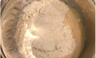 Bột được đổ vào khối kefir theo từng phần, muối được thêm vào, đồng thời bột được nhào cho đến khi có kết cấu đồng nhất và để yên trong 10 - 15 phút.