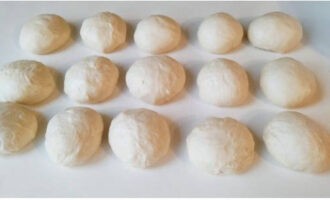 Dividiu la massa esponjosa en segments de 50-60 grams de pes i enrotlleu-les en boles, deixeu-ho 5 minuts sota una tovallola.