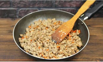 Folosind o spatulă, spargeți cocoloașele de carne și prăjiți până când lichidul se evaporă și culoarea își schimbă.