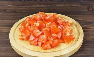 Ta bort stjälkarna på tomaterna och skär sedan frukterna i små bitar.