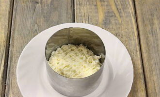 Dùng một chiếc nhẫn xếp salad thành từng lớp. Đầu tiên, thêm lòng trắng và đổ sốt mayonnaise lên trên.