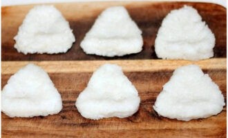 Chúng tôi tạo thành những hình tam giác dày đặc, gọn gàng từ cơm đông lạnh và tạo một vết lõm nhỏ trên đó.