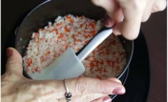 Để tạo thành món salad, hãy lấy một chiếc nhẫn chia đôi và đặt nó lên đĩa.Đặt lớp que cua thái lát đầu tiên lên và phủ một lớp sốt mayonnaise lên.