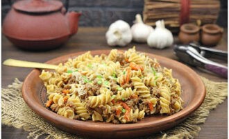 Pastele marine cu carne tocată într-o tigaie sunt gata! Așezați vasul aromat pe farfurii porționați și stropiți cu așchii de brânză și gust. Poftă bună!