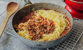 Lägg pasta i köttsås. Blanda.