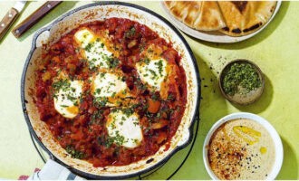 Espolvorear la clàssica shakshuka israeliana amb julivert picat i servir amb salsa tahini, pa de pita i olives. Bona gana!
