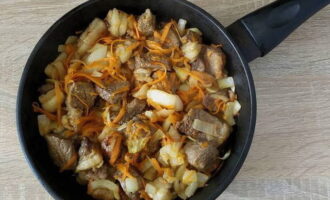 Se adauga legumele tocate in carne, se amesteca si se prajesc 5-7 minute la foc moderat.