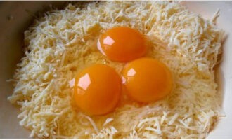 ชีสบอลเตรียมง่ายๆ ที่บ้าน บดชีสโดยใช้เครื่องขูดและตีไข่ไก่ลงในเศษชีส