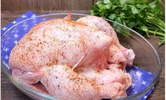 Ang inihurnong manok sa oven ay napakadaling ihanda. Hugasan nang maigi ang bangkay ng manok at tuyo ito ng mga tuwalya ng papel. Susunod, kuskusin ang ibon sa lahat ng panig na may asin at pampalasa. Kuskusin din namin ito sa loob. Pagkatapos ay ilagay ang workpiece sa isang baking dish.