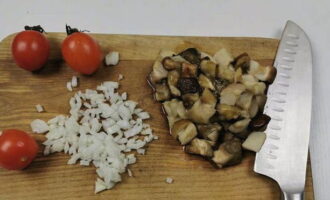 Risotto cu ciuperci este foarte ușor de preparat. În primul rând, să gătim un bulion de legume dintr-un litru de apă, morcovi, rădăcină de țelină, un cățel de usturoi și o jumătate de ceapă. Tăiați ceapa rămasă în cuburi mici. Dezghețați ciupercile porcini și tăiați-le în bucăți mai mici.